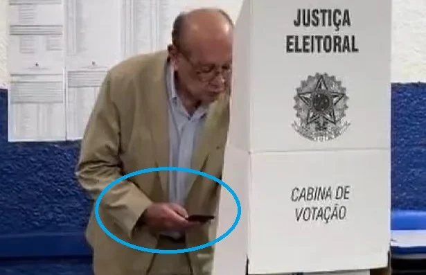 Gilmar Mendes usa celular na cabine de votação em Cuiabá, contrariando regras eleitorais